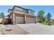 Exterior view of a two-story home featuring a three-car garage and beautifully landscaped yard at 58 Rogers Ct, Golden, CO 80401