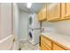 Compact laundry room features stacked washer and dryer, with wood cabinets and counter space for folding at 58 Rogers Ct, Golden, CO 80401