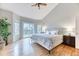 Spacious main bedroom with hardwood floors, a ceiling fan, large windows, and sliding doors leading to a balcony at 58 Rogers Ct, Golden, CO 80401
