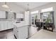 Sunlit kitchen featuring white cabinets, a center island, stainless steel appliances, and backyard access at 5133 S Liverpool Way, Centennial, CO 80015