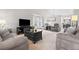 Spacious living room with comfortable seating, a large TV, and neutral decor throughout the space at 5133 S Liverpool Way, Centennial, CO 80015