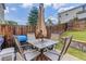 Private backyard featuring a patio set with umbrella, grill, lush greenery, and privacy fence at 5546 S Quemoy Cir, Aurora, CO 80015