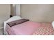A bedroom featuring a single bed with a floral pattern, neutral walls, and an open door at 5546 S Quemoy Cir, Aurora, CO 80015