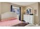 A bedroom features a single bed with light walls, neutral carpet, natural light, and a modern dresser at 5546 S Quemoy Cir, Aurora, CO 80015
