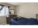 Bedroom with a dark wood dresser and accent mirror, single bed, and natural light at 5546 S Quemoy Cir, Aurora, CO 80015