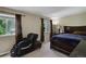 Bedroom with carpet, a bed with a plush blanket, a massage chair, and a window with natural light at 5546 S Quemoy Cir, Aurora, CO 80015