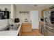 Modern kitchen features stainless steel dishwasher, light wood cabinets, and a white door at 5546 S Quemoy Cir, Aurora, CO 80015