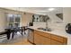 Well-lit kitchen with stainless steel appliances, wood cabinets, and a dining area with sliding glass doors at 5546 S Quemoy Cir, Aurora, CO 80015