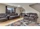 Elegant living room featuring classic leather sofas, hardwood floors, and tasteful decor, ideal for relaxation at 5546 S Quemoy Cir, Aurora, CO 80015