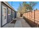 View of the side yard with a concrete pathway, fence, and access to the house at 3300 W 2Nd Ave, Denver, CO 80219