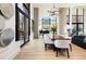 Bright dining area features a wooden table, white chairs, and large windows with decorative lighting fixture above at 100 Detroit St # 103, Denver, CO 80206