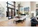 Bright dining area features a wooden table, white chairs, and large windows with decorative lighting fixture above at 100 Detroit St # 103, Denver, CO 80206