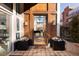 Elegant home entryway with wood door, outdoor plants, and a view into a stylishly decorated interior living space at 100 Detroit St # 103, Denver, CO 80206