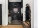 Hallway featuring dark walls, hardwood floors, decorative mirror and table, enhancing the modern and chic aesthetic at 100 Detroit St # 103, Denver, CO 80206