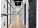 Bright hallway featuring light wood floors and gallery walls with black and white framed pictures at 100 Detroit St # 103, Denver, CO 80206