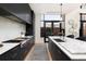 The modern kitchen features black cabinets with marble countertops, stainless steel appliances and lots of lighting at 100 Detroit St # 103, Denver, CO 80206