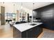 Open concept kitchen with a marble island, modern black cabinets, and stainless steel appliances at 100 Detroit St # 103, Denver, CO 80206