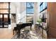 The piano sits near a window with sheer curtains, and a modern chandelier at 100 Detroit St # 103, Denver, CO 80206