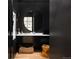 Modern powder room with a round mirror, marble countertop and a decorative basket at 100 Detroit St # 103, Denver, CO 80206