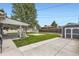 A spacious backyard with lush green lawn, patio, shed and white fencing at 5150 W Colgate Pl, Denver, CO 80236