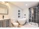 Elegant bathroom features a modern vanity, soaking tub, and stylish glass enclosed shower at 5150 W Colgate Pl, Denver, CO 80236