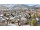 Elevated view of neighborhood with snow-dusted roofs and distant mountains, blending urban living with nature's beauty at 6459 S Queen Way, Littleton, CO 80127