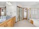 Bright bathroom with double sinks, mirrored closet, and glass-enclosed shower at 6459 S Queen Way, Littleton, CO 80127