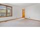 Bright bedroom featuring plush carpeting, wood trim, and a large window offering natural light at 6459 S Queen Way, Littleton, CO 80127