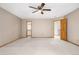 Spacious bedroom with ceiling fan, neutral carpet, and wood trim throughout the room at 6459 S Queen Way, Littleton, CO 80127