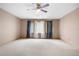 Neutral bedroom featuring a ceiling fan, neutral carpet, and windows with curtains at 6459 S Queen Way, Littleton, CO 80127