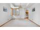 Bright living room with large windows, new carpet, and access to other rooms at 6459 S Queen Way, Littleton, CO 80127