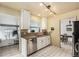 Bright kitchen with granite countertops, stainless steel appliances, and a view to the sunroom creates an inviting space at 8094 E Kenyon Pl, Denver, CO 80237