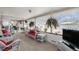 Bright sunroom with white wicker furniture and view to backyard at 8094 E Kenyon Pl, Denver, CO 80237