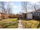 A grassy backyard with a brick house, a shed and a wooden fence in the distance at 4344 Wyandot St, Denver, CO 80211