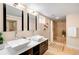 Bright bathroom featuring dual sinks, modern fixtures, and a tiled shower at 4344 Wyandot St, Denver, CO 80211