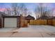 Back exterior of a brick house with a garage, a small shed, a wooden fence and a patch of dry grass at 4344 Wyandot St, Denver, CO 80211