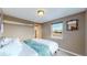Comfortable bedroom with natural light from the window and soft blue quilted blanket at 3282 W 66Th Ave, Denver, CO 80221