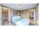 Bright bedroom with king-size bed, adjacent bathroom access, and a view of the hallway at 3282 W 66Th Ave, Denver, CO 80221