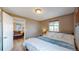 A cozy bedroom with hardwood floors, and a doorway leading into the living room at 3282 W 66Th Ave, Denver, CO 80221