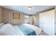 Bedroom with hardwood floors, closet, and doorway to en-suite bath at 3282 W 66Th Ave, Denver, CO 80221
