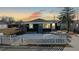 Updated bungalow exterior at sunset, white picket fence, landscaping at 3282 W 66Th Ave, Denver, CO 80221