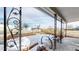 View from covered porch featuring decorative metal railings, bike-rim art, and partial snow covering at 3282 W 66Th Ave, Denver, CO 80221