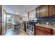 A well-appointed kitchen with stainless appliances and wood cabinets, adjacent to a sunlit dining space at 3282 W 66Th Ave, Denver, CO 80221