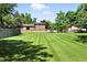 Spacious backyard with lush green lawn and mature trees, offering ample space for outdoor activities at 1380 Holly E Dr, Broomfield, CO 80020