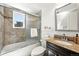 Bathroom with shower-tub combo, frosted glass door, granite countertop on dark cabinet and large mirror at 1380 Holly E Dr, Broomfield, CO 80020