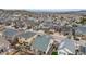 An aerial view showcases a neighborhood with varied home styles, lush lawns, and mountain views at 3502 First Light Dr, Castle Rock, CO 80109