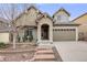 Inviting home exterior showcases a covered front porch and neatly landscaped yard leading to the attached two-car garage at 3502 First Light Dr, Castle Rock, CO 80109