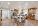 Spacious kitchen featuring a central island with seating, wood cabinets, stainless steel appliances, and wood flooring at 3502 First Light Dr, Castle Rock, CO 80109