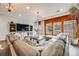 Stylish living room features a large leather sectional sofa, bright windows, and an orange accent wall at 3502 First Light Dr, Castle Rock, CO 80109