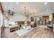 Open-concept living room flows into kitchen, featuring a large leather sectional, recessed lighting, and bright windows at 3502 First Light Dr, Castle Rock, CO 80109